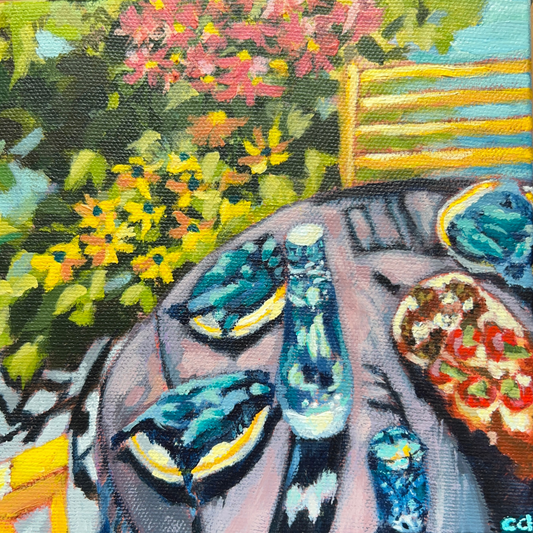 A painting depicting a dining al fresco scene with plates, cutlery, and a bottle arranged on a table, set against a backdrop of colorful flowers and greenery.