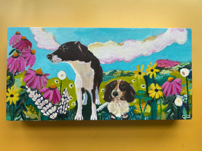 Painting of two dogs in a field of flowers on a yellow background